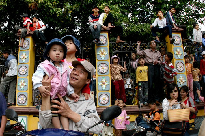 Tường rào đình làng Đồng Kỵ kín người đu bám để xem lễ rước Ông Đám trong hội làng Đồng Kỵ (xã Đồng Quang, thị xã Từ Sơn, tỉnh Bắc Ninh).