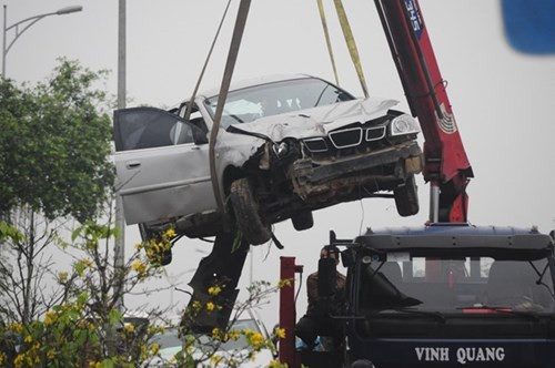 Cú tông mạnh khiến thân xe taxi bị dập nát hoàn toàn và bị đẩy cách xa vị trí đỗ xe hơn 10 m. Riêng ôtô mang BKS 73A bị dập nát phần đầu. Hai xe bị nạn được cẩu ra khỏi hiện trường. Ảnh: Điền Quang.