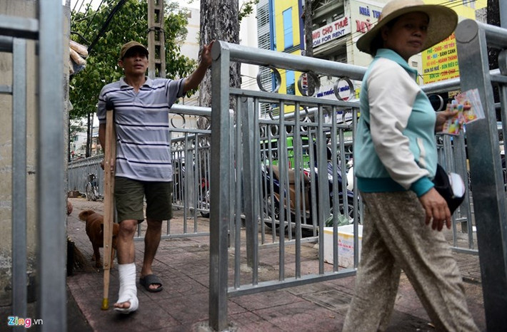 Khu vực này trở thành nơi đặt bàn ghế, mắc võng ngủ trưa của nhiều người. Lối đi zíc zắc không thuận tiện nên nhiều người chọn cách đi xuống lòng đường. Không gian trước bệnh viện càng thêm mất thẩm mỹ khi có hệ thống lối chắn này. Ảnh: Zing.