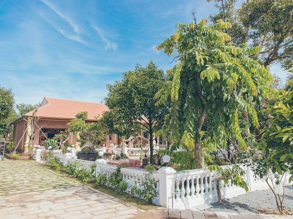 Biệt phủ có tông màu đỏ, trắng chủ đạo và được bao bởi nhiều cây xanh. Ảnh: FBNV