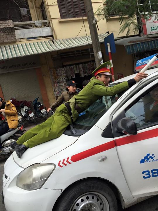Khoảng 15h10 chiều 5/2/2015, trên phố Tuệ Tĩnh (HN), tổ công tác phát hiện chiếc taxi BKS 30P-4406 chạy vào đường cấm nên ra hiệu lệnh dừng xe. Tuy nhiên thay vì dừng lại, chiếc taxi tiếp tục nhấn ga chạy thẳng, hất một cảnh sát trong tổ công tác lên nắp capo và tiếp tục bỏ chạy. Ảnh: Vitalk.