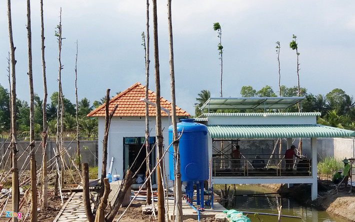 Phía sau có nhà chứa vật tư, hệ thống xử lý nước, nhà sàn gỗ với mái tôn cách nhiệt và phía trên có hệ thống điện mặt trời.
