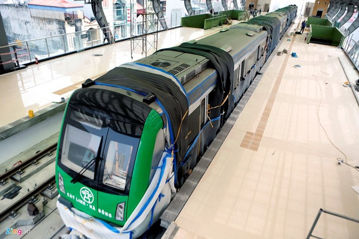 Đoàn tàu tuyến Cát Linh-Hà Đông được lắp đặt lên hệ thống ray đã 2 tháng nhưng tuần qua mới lộ diện sau khi công nhân mở các tấm vải xốp phủ xung quanh. Về hình dáng, đầu tàu trông không khác nhiều so với toa tàu mẫu được trưng bày hồi cuối tháng 10/2015, vẫn giữ nguyên màu sơn xanh và biểu tượng Khuê Văn Các của Hà Nội. Ảnh: Zing.