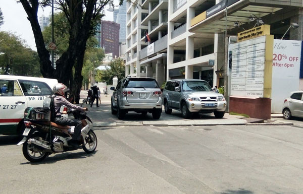 Ngoài ra, tại các trung tâm thương mại, khách sạn lớn trên đường Tôn Đức Thắng, ô tô đậu khắp nơi trên vỉa hè khi không có đoàn kiểm tra. Trong ảnh, 2 ô tô chiếm dụng vỉa hè, trong đó có xe biển xanh 50A.