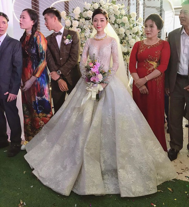 Trong lễ cưới, cô dâu Nhật Linh thay ba bộ đầm trắng ở buổi tiệc, trong đó được chú ý nhất là bộ đầm ren phom dáng cồng kềnh khi làm lễ. Được biết, bộ đầm có giá 600 triệu đồng, được lấy ý tưởng từ bầu trời sao lấp lánh. Ảnh: Zing.