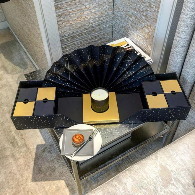 Hộp bánh của Dior sang trọng và tinh tế với phông nền đầy sao cùng cánh quạt in tên thương hiệu. Hộp nến đặt chính giữa giúp thắp sáng đêm trung thu. Ảnh: Instagram.