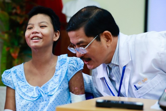 Bác sĩ Phan Vũ Bảo, quyền Trưởng khoa Bỏng, người trực tiếp điều trị cho Linh ròng rã gần 2 tháng qua, vỗ về động viên cô bé.