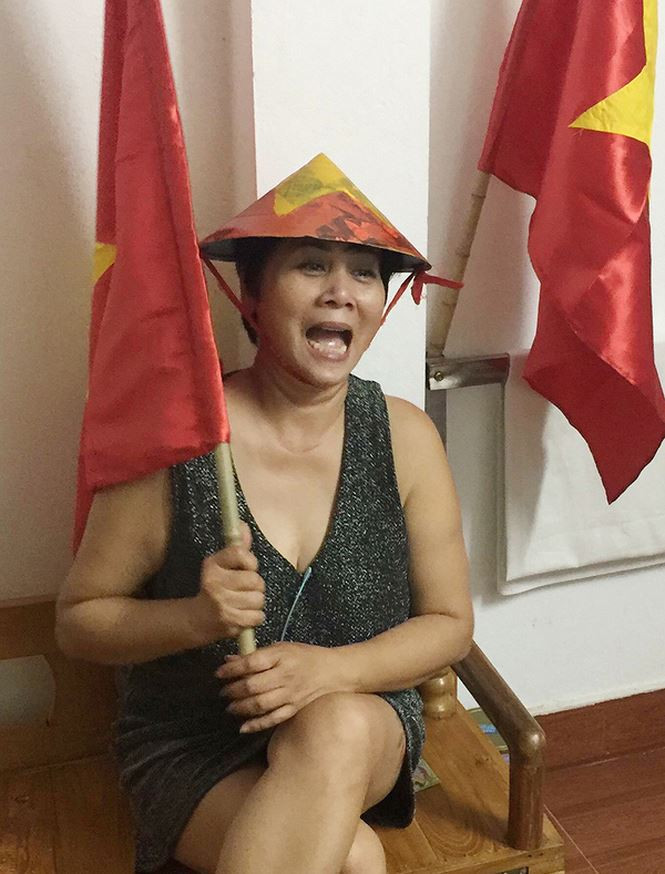 Nghệ sĩ Minh Hằng đội nón, cầm cờ để chung vui với đội tuyển nước nhà.