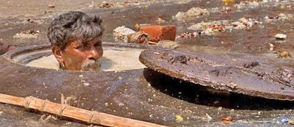 Tại Ấn Độ, có hàng trăm nghìn người lao động trình độ thấp sẵn sàng làm những công việc chân tay như làm sạch cống hay bể chứa rác thải mà không có thiết bị bảo hộ lao động.
