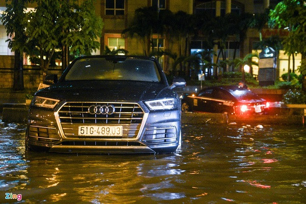 Một chiếc Audi nằm bất động giữa dòng nước gần 4 giờ. Anh Trường, chủ nhân chiếc xe chia sẻ sóng nước lớn đã khiến xe của anh quay đầu, nằm ngang giữa đường.