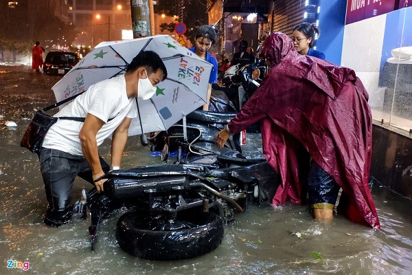 Những chiếc xe máy trên vỉa hè cũng bị sóng nước làm đổ la liệt.