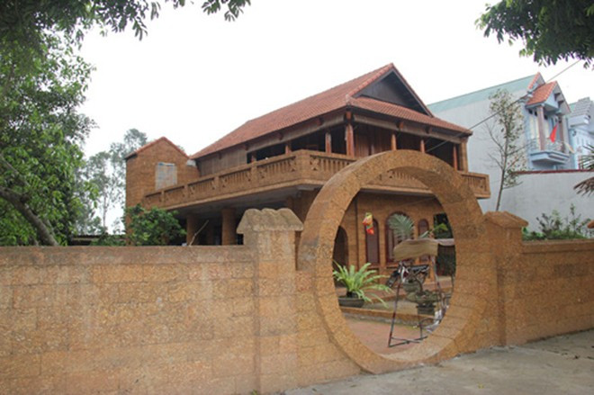 Nhà gỗ mít độc đáo với cổng vào xây bằng đá ong. Ảnh: Vietnamnet.