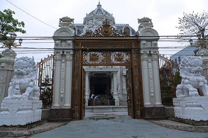 Hệ thống cổng, hàng rào tòa lâu đài được làm bằng chất liệu nhôm hợp kim mạ đồng. Cánh cổng được điều khiển bằng hệ thống từ xa. Ngoài ra, xung quanh gắn 20 camera và lớp hàng rào thép gai để đảm bảo an ninh. Ảnh: Vietnamnet.