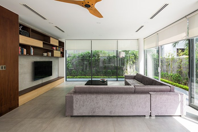 Phòng khách đơn giản nhưng hiện đại với hệ cửa kính lớn bao quanh.