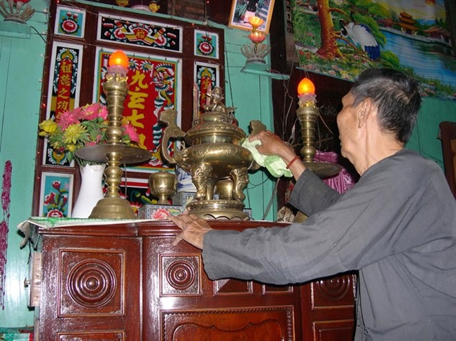 Lão nông ở Đồng Tháp lau chùi bàn thờ trong nhà