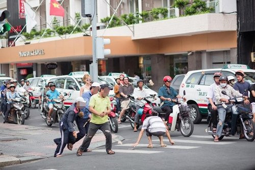 Hành động ném tiền kỳ lạ này đã thu hút sự chú ý của nhiều người đi đường và tạo ra cảnh tượng náo động giữa ngã tư. Nhiều người đi đường khi thấy tiền bay đã dừng xe nhặt. Một số người còn hò reo khi nhặt được tiền. (Ảnh cắt từ clip)