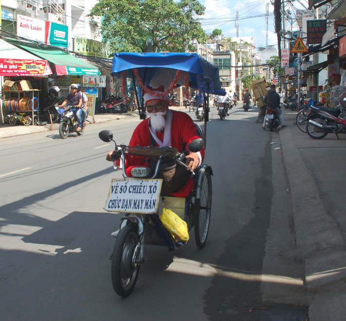 Ông già Noel kinh doanh thêm bán vé số. Ảnh: Yeah1.