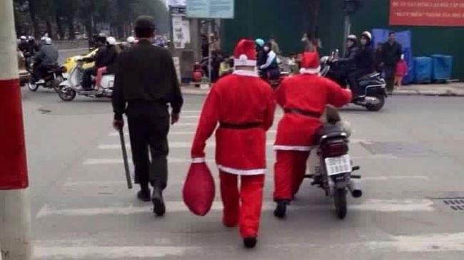 Chỉ vì mải giao quà đúng hẹn cho các cháu, hai ông già Noel phiên bản Việt đã bị các cảnh sát cơ động "hỏi thăm" vì không đội mũ bảo hiểm khi tham gia giao thông. Ảnh: Facebook.