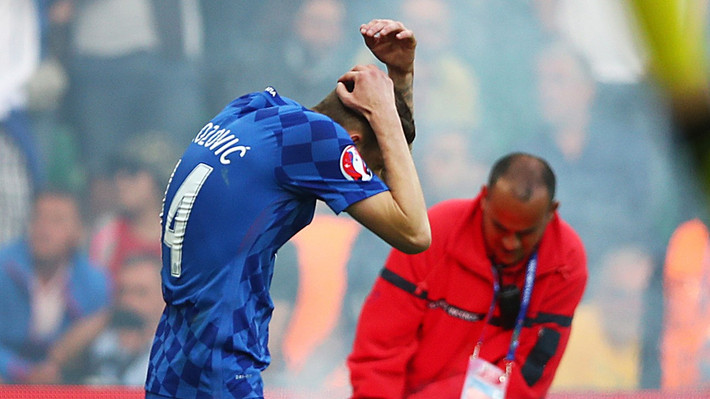 Các CĐV Croatia còn ném những quả pháo sáng về phía các cầu thủ của mình. Cầu thủ Brozovic đã phải ôm đầu để tránh những quả pháo sáng từ trên khán đài.