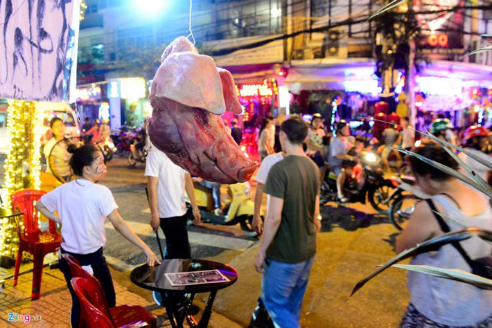 Đầu heo treo lủng lẳng trước cửa nhà ở đường Bùi Viện, nơi tập trung đông người mỗi tối.