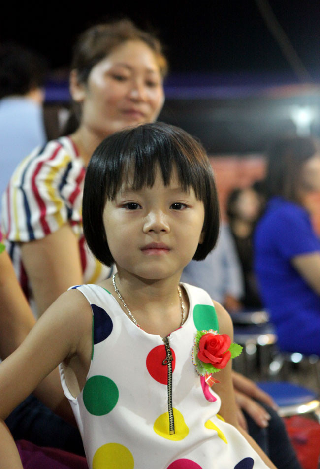 Các em nhỏ vui sướng được gắn một bông hồng màu đỏ trên ngực.