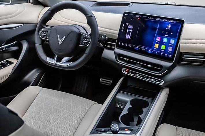 VF7 được thiết kế hướng tới người lái, với các điểm nhấn ở nội thất là màn hình giải trí cảm ứng cỡ lớn lên tới 12,9 inch, hệ thống hiển thị thông tin trên kính lái HUD, vô lăng D-cut phối hai màu độc đáo cùng dàn phím bấm chuyển số được thiết kế tinh tế như những phím đàn piano.