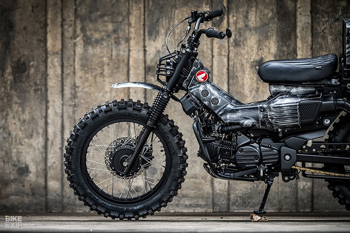 Thoạt nhìn, chúng ta có thể thấy bản độ Honda CT125 Combat được làm y như một mẫu xe Classic Scrambler với dáng vẻ cao ráo và dày dặn hơn trước rất nhiều. Khung chống đổ bản lớn được gắn vào khung sườn tạo ra sự chắc chắn cho chiếc xe.