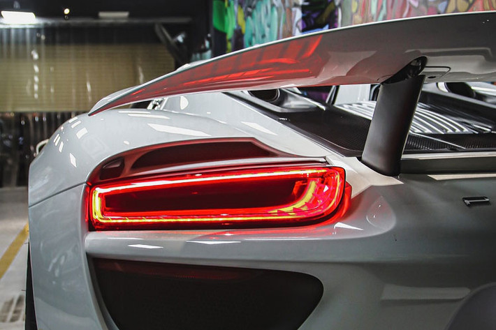 Chiếc siêu xe Porsche 918 Spyder về Việt Nam thuộc bản tiêu chuẩn, ngoài bộ áo trắng xe còn có nhiều chi tiết carbon và bộ mâm đa chấu cá tính. Phần mui của Porsche 918 Spyder chia thành 2 phần và dễ dàng tháo lắp bằng tay, ngay trên đầu người ngồi sẽ có 2 chốt để mở mui, chủ nhân sẽ quyết định cất 2 mui này vào trong khoang hành lý phía trước hay có thể để ở bên ghế phụ.