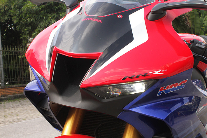 Thiết kế của Honda CRB1000RR-R SP 2020 mới sở hữu diện mạo hầm hố hơn hẳn CBR1000RR thế hệ cũ từng bán ra tại Việt Nam. Phần đầu xe dữ dằn với cụm đèn LED được vuốt xéo lên, bên trong là 4 thấu kính chia đều cho 2 bên. Ở giữa cụm đèn là hốc hút gió cỡ lớn - thiết kế quen thuộc trên những dòng siêu môtô đình đám.