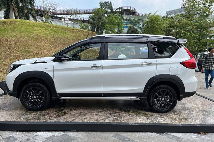 Ngoại hình mẫu xe MPV Suzuki XL7 Hybrid giá mềm tại thị trường Indonesia được tinh chỉnh nhẹ để trở nên thể thao hơn so bản thuần xăng. Theo đó, lưới tản nhiệt sơn màu đen mới thay vì mạ crôm như trước, vành la-zăng 16 inch cũng sơn đen đầy khỏe khoắn. Đèn pha có thêm tính năng tự động bật/tắt với cảm biến ánh sáng và tính năng chờ dẫn đường (Guideline Me Light) mới, gương chiếu hậu tự động gập mới.