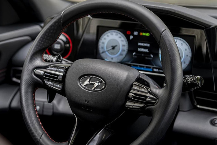 Bước vào bên trong, mọi thiết kế trên Hyundai Elantra 2023 dường như không còn vương vấn bất kỳ chi tiết nào từ thế hệ cũ. Cửa gió điều hòa được làm lại theo hướng thanh mảnh và đặt ẩn trong 3 đường crom chạy ngang bảng táp-lô đầy tinh tế. Đi cùng với đó là tay nắm cỡ lớn trên bệ trung tâm.