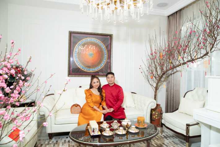 Phòng khách rộng rãi đặt bộ sofa trắng ngà kết hợp cùng đèn trần lộng lẫy tô điểm thêm vẻ sang chảnh và ấm áp cho ngôi nhà. Ảnh: Maison de Bil
