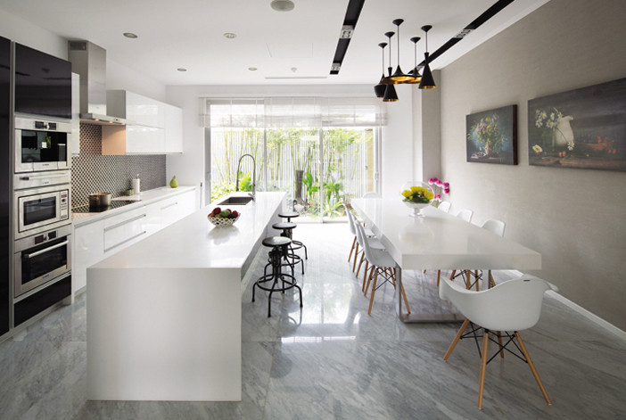 Nhà bếp ngập ánh sáng với bức tường kính trong suốt nhìn ra khu vườn.