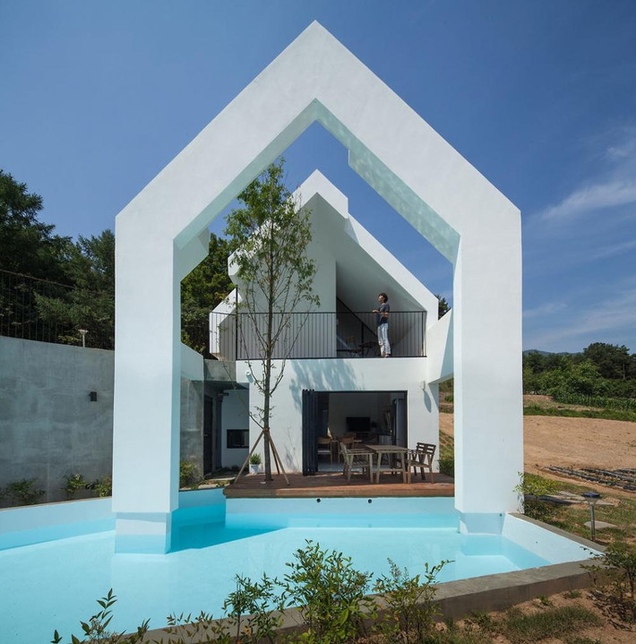 Nhà mái dốc độc đáo có bể bơi xanh mát giúp điều hòa không khí. Ảnh: Archdaily.