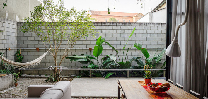 Khoảng sân sau được bố trí những bụi cây cảnh nhỏ làm không gian thư giãn.