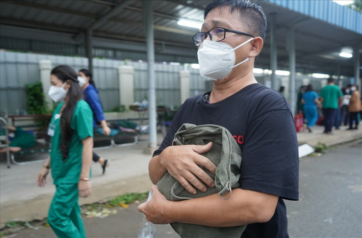 Trong túi đồ của người cha đã mất mà anh Minh Đức (ngụ quận 10) nhận được còn sót chiếc điện thoại, để thuận tiện hơn, nhân viên y tế dẫn anh vào tận kho đồ để cùng tìm kiếm. Dưới mưa, anh vẫn ôm chặt chiếc túi vào ngực. Nước mắt anh không ngừng rơi từ khoé mắt kể từ khi anh bước vào bệnh viện, giờ đây hoà cùng vào nước mưa.
