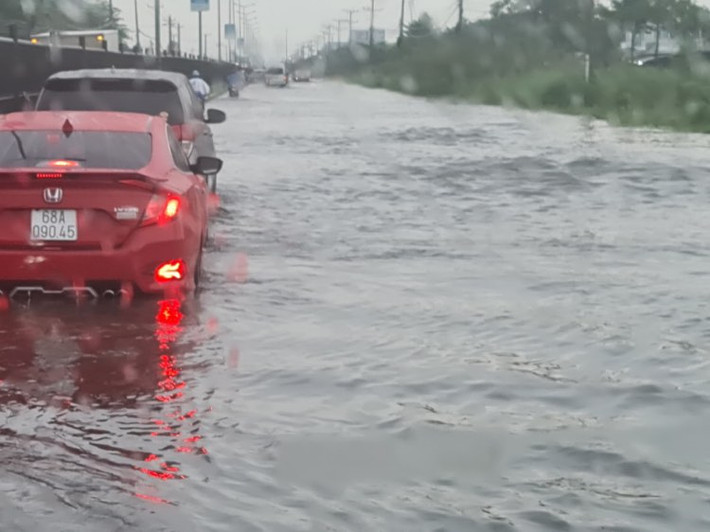 Chiều 12/6, sau cơn mưa kéo dài hơn 2 tiếng, đoạn quốc lộ 1 qua khu công nghiệp Hòa Phú, huyện Long Hồ, tỉnh Vĩnh Long biến thành sông. Ảnh: An Quý