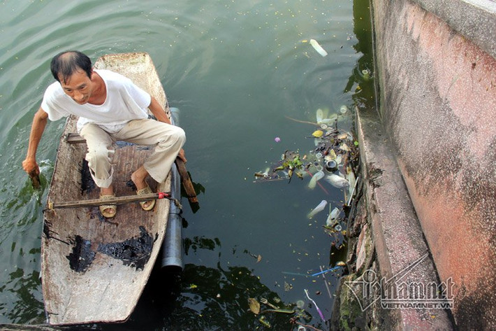 Một người dân chèo thuyền ra vớt.