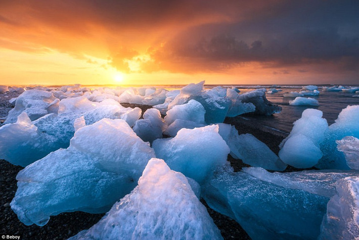 Cảnh tượng bình minh trên bờ biển phủ đầy băng chưa tan ở Iceland. (Nguồn: Daily Mail)