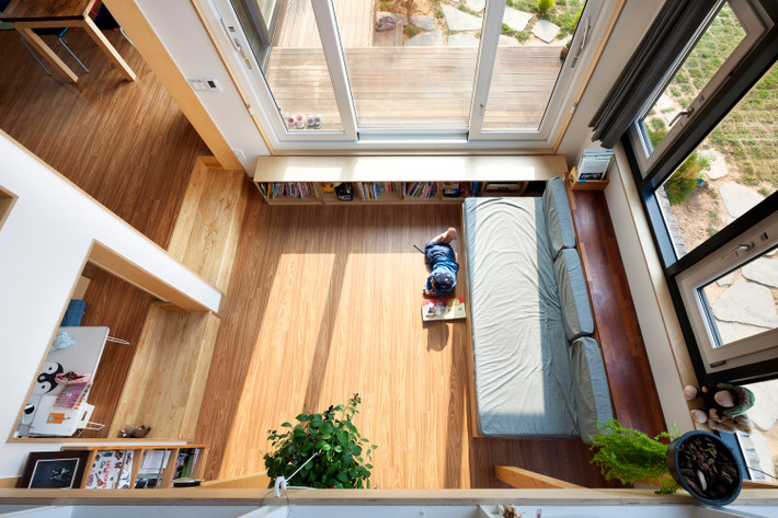 Phòng khách cực kỳ thoáng đãng. Ghế sofa kê sát tường để lấy diện tích cho bé vui chơi.