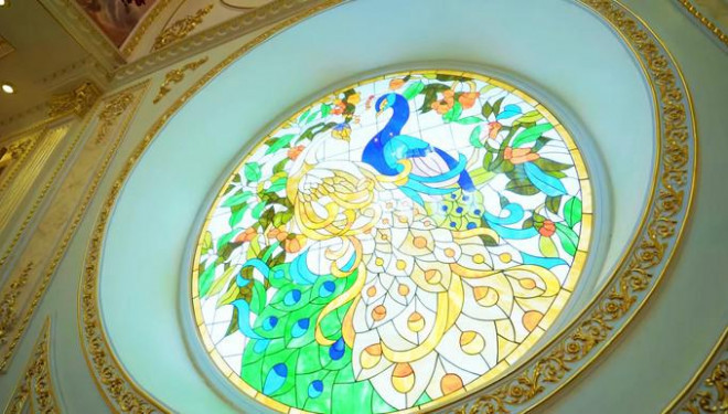 Tường nhà nổi bật với lớp kính xuyên sáng hình đôi chim công.