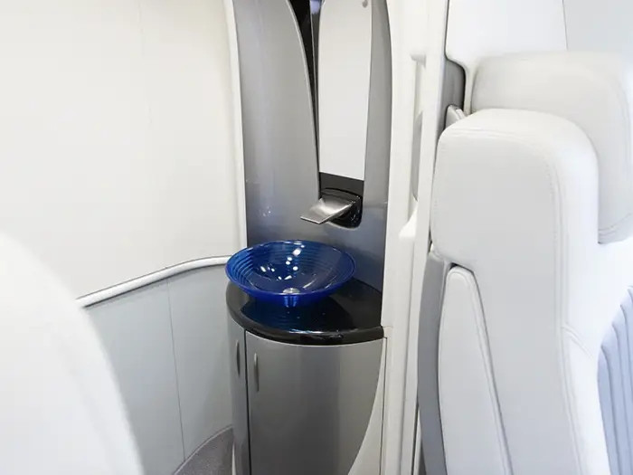 Phòng vệ sinh khép kín với bồn cầu và bồn rửa, được ngăn cách với cabin chính bằng cửa trượt.