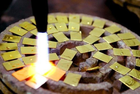Một cách khác cầu kỳ và cần nhiều kỹ thuật hơn đó là dùng lửa khò để phân biệt vàng thật vàng giả. Nếu như vàng tan mà vẫn còn lớp bột ráp bám trên bề mặt cắt thì nhiều khả năng là vàng đã bị pha trộn kim loại khác. Tuy nhiên, cách này chỉ có thể do chủ các cửa hiệu bán vàng hoặc những thợ kim hoàn có kinh nghiệm mới có thể làm. Cách này cũng làm hao hụt lượng vàng khách mua.