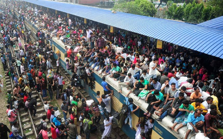 Hành khách chen nhau trèo lên một chuyến tàu hỏa quá tải ở thành phố Dhaka, Bangladesh.