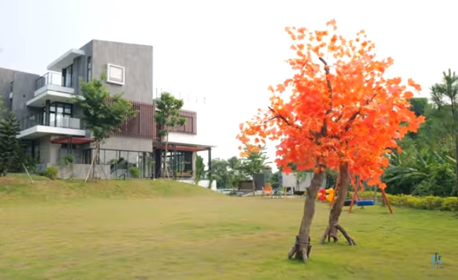 Khu vực sân vườn rộng lớn với thảm cỏ xanh mướt và rất nhiều cây cối xung quanh.
