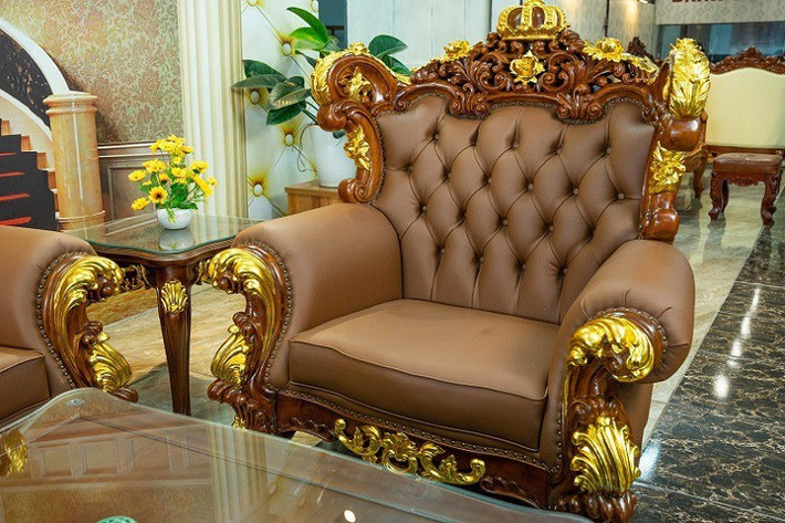 Lấy cảm hứng từ vương miện vàng son thể hiện sự hưng thịnh của gia tộc, bộ bàn ghế được chạm trổ hoa văn tinh xảo dát vàng 24K, toát lên sự sang trọng, quý phái. Ảnh: Người đưa tin