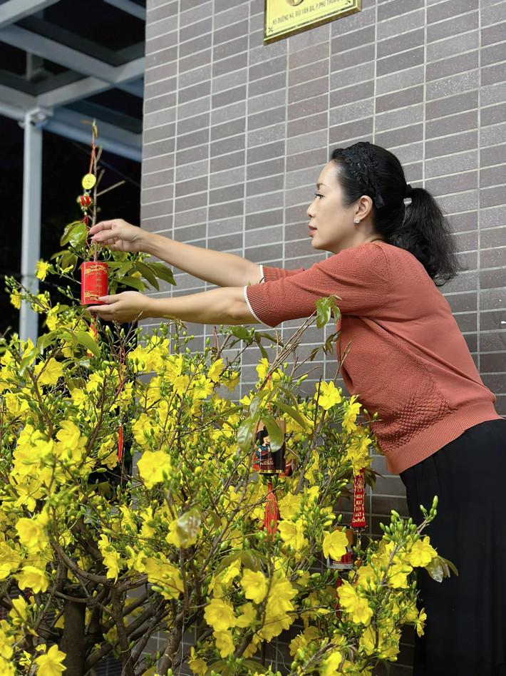 Ngày Tết, nàng hậu trang trí cho cây mai vàng thêm bắt mắt.