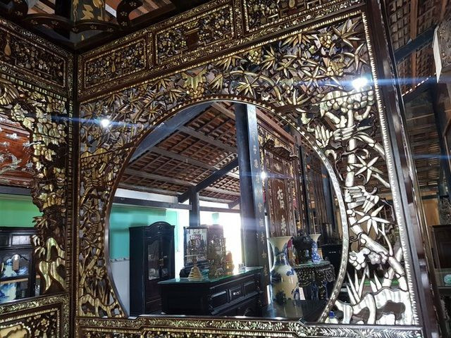 Giường cổ trăm tuổi được chạm khắc, khảm ốc xà cừ chiếu 7 màu rất tinh xảo. Ảnh: T.L