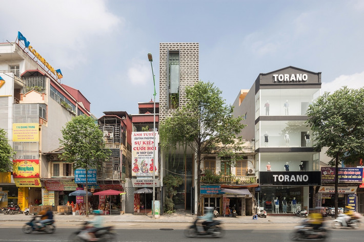 Nằm trên một tuyến đường lớn với mật độ dân cư cao tại Hà Đông (Hà Đông, Hà Nội), mặt tiền căn nhà được thiết kế hai lớp với lớp vỏ ngoài cùng bằng gạch xếp tạo lỗ còn lớp trong bằng kính khung sắt. Nhờ đó, ngôi nhà chắn được bụi bẩn, tiếng ồn mà vẫn sáng và thông thoáng. Ảnh: Oddo Architects