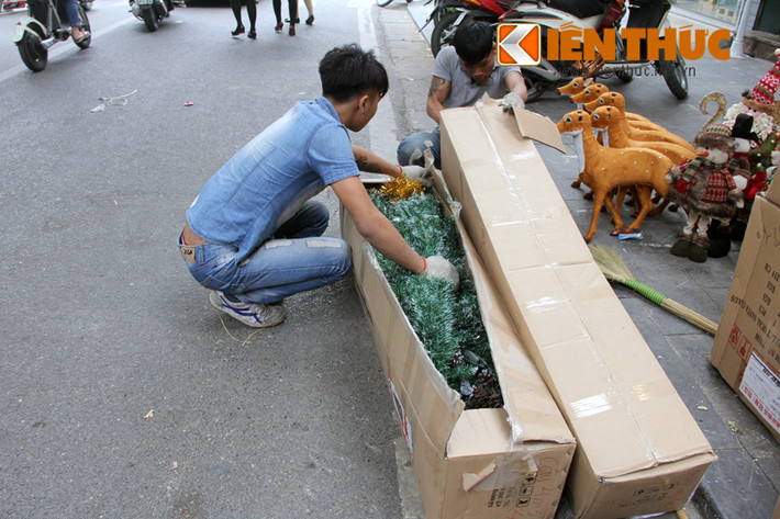 Nhân viên cửa hàng bán đồ trang trí đang gỡ thùng hàng vừa được chuyển đến.